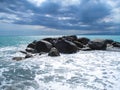 Sea Ã¢â¬â¹Ã¢â¬â¹coast with rocks after a storm, black clouds in the sky. Royalty Free Stock Photo